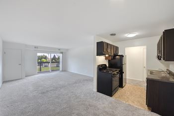 Open kitchen with black appliances and living room
